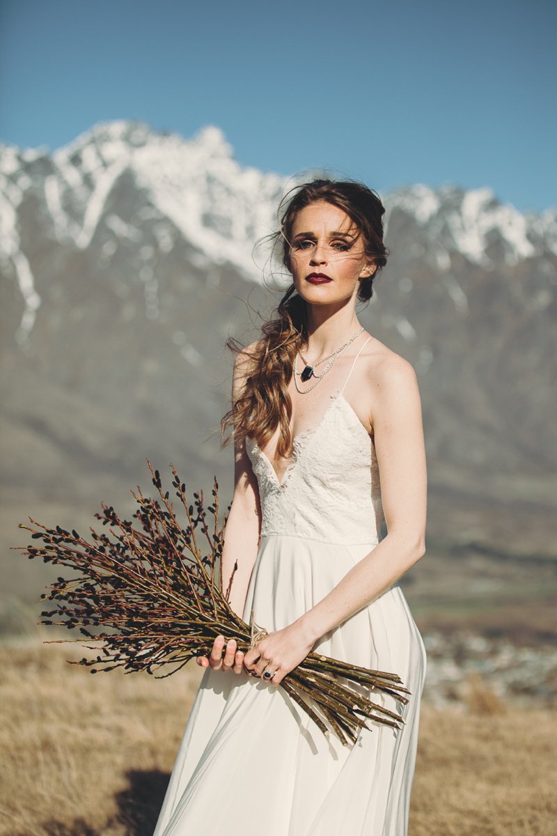 NZ High Country wedding venue with views of The Remarkables and bride wearing Rue De Seine Mackenzie gown and The Flower Room bouquet
