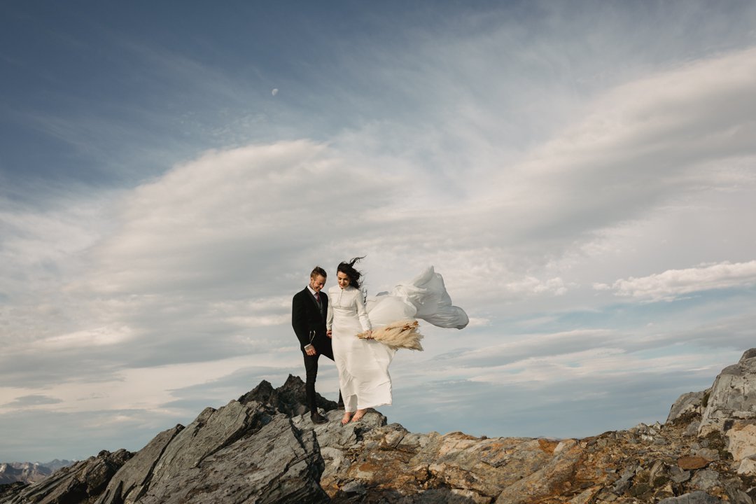 Bride and groom in flowing white dress and vintage suit for their wild Queenstown mountain top elopement by Dawn Thomson Photography