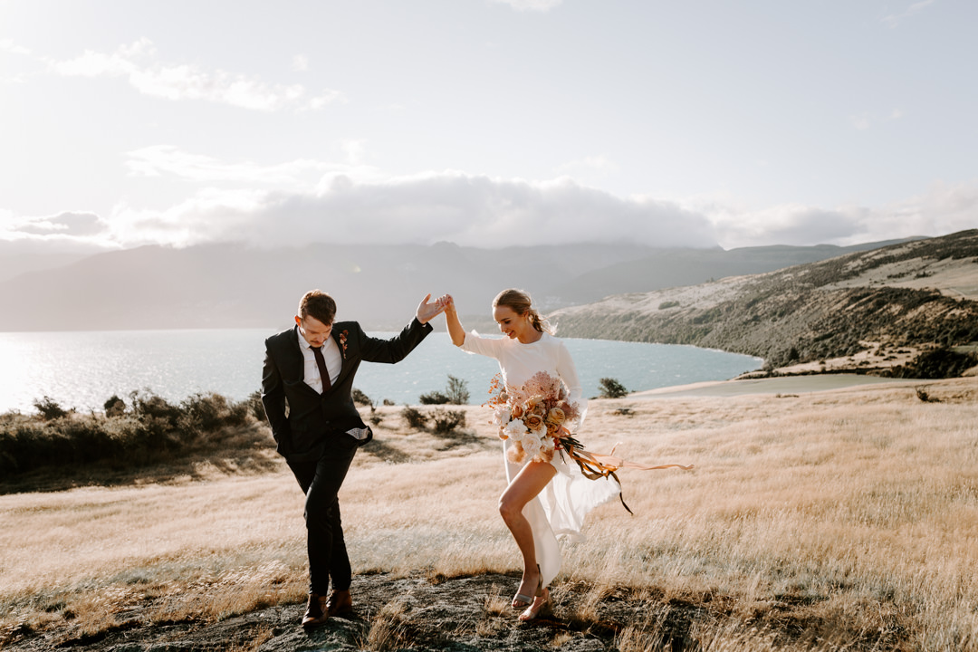 Bride and Groom lake side at Jacks Retreat Elopement Wedding in Queenstown, New Zealand by Dawn Thomson Photography